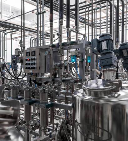 Photo of grey pipes and tanks. Chemistry and medicine production. Pharmaceutical factory. Interior of a high-tech factory, modern production.